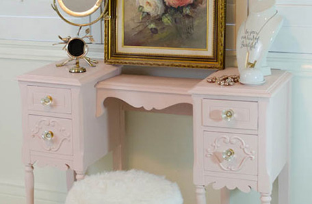 angled view of finished vanity painted pale pink with furnishings and decor