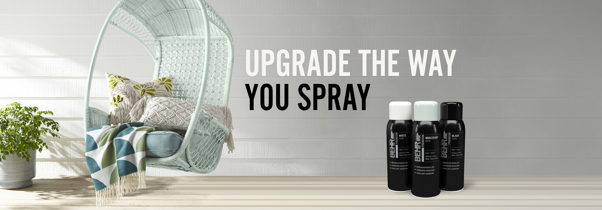 Behr Premium Spray paint cans with a chair in the background and text overlay that says Upgrade the way you spray.