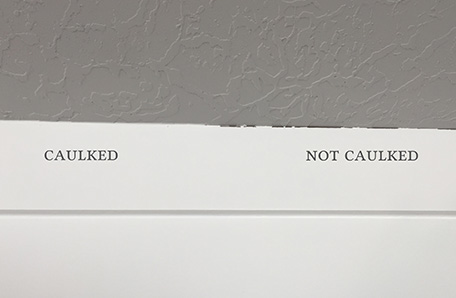 Painted wall showing the difference between caulked and uncaulked seams
