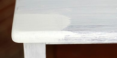 Dresser top showing the difference between one coat and two coats of paint