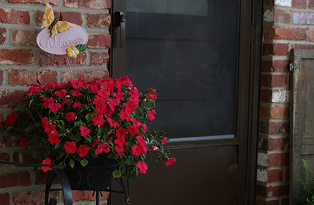 A bright red impatiens dresses up the entryway nicely