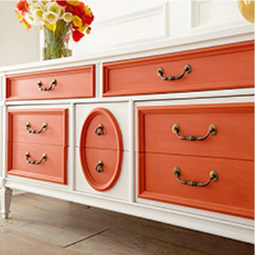 Orange and white dresser with flowers on the table