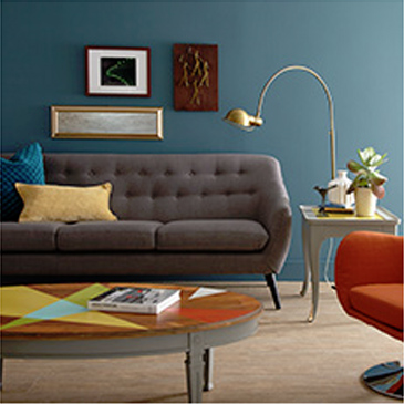 Living room with dark gray couch, orange chair, and coffee table