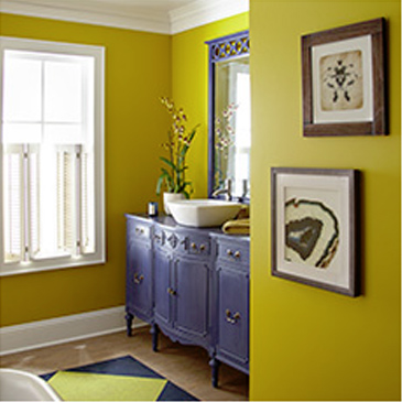 Yellow room with blue dresser, window, and two pictures hanging on the wall