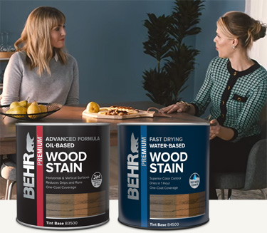 Mobile version of two ladies sitting at stained dining table with Behr interior wood stain products in foreground