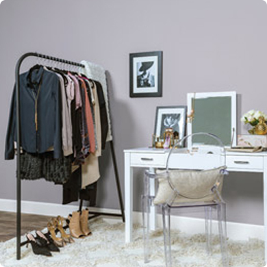 Bedroom with a clothing rack and a white table