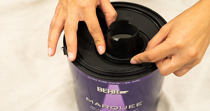 Close up of person placing Simple Pour Lid on can.
