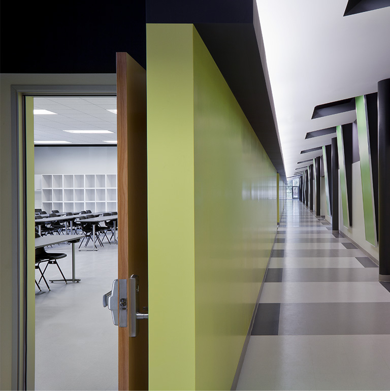 An image of a small empty classroom hallway with a green, gray and white color combination.