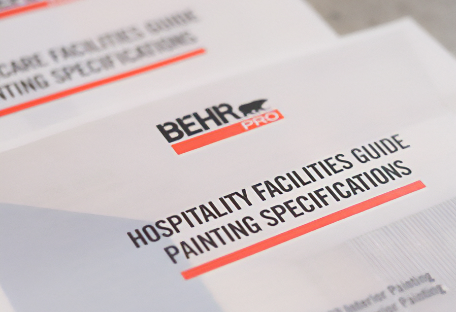 Close up image of a BEHR PRO Hospitality Guide Painting Specifications and Healthcare Facilities Guide Painting Specifications documents on a terrazzo surface.