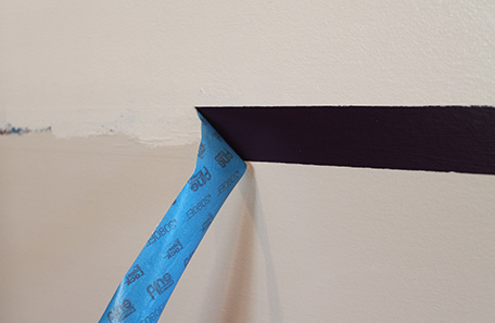 Removing the painter’s tape to reveal a purple stripe