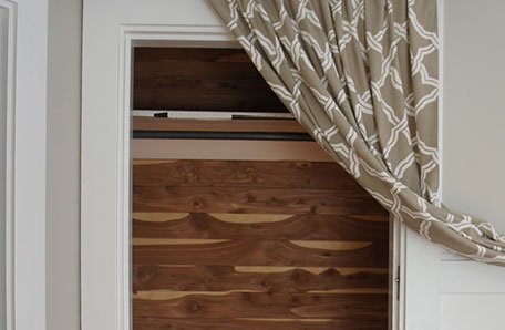 unpainted cedar closet with curtain draped to side