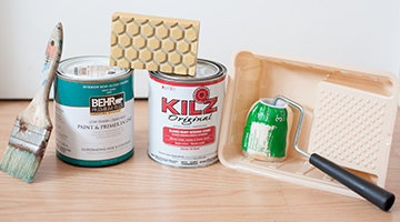 Gallon cans of BEHR PREMIUM PLUS paint and KILZ ORIGINAL primer