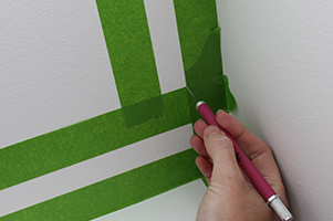 edges of painters tape being cleaned up with craft knife