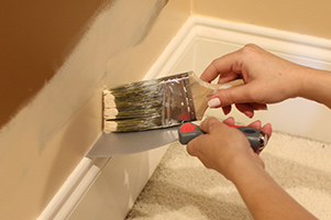 painting wall and using putty knife for edging