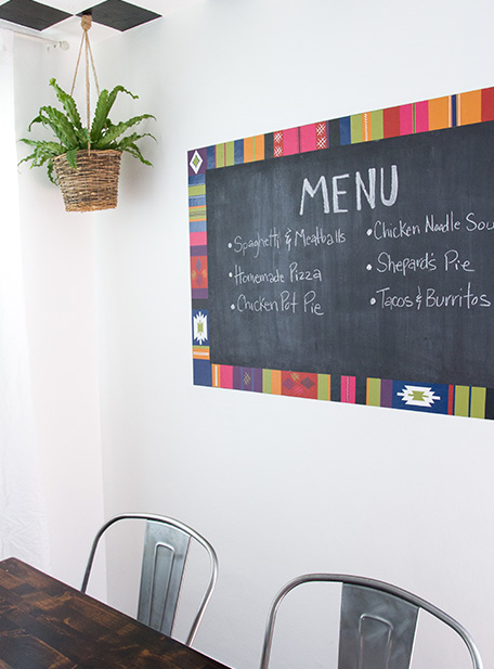 dining room with Taurkish rug inspired chalkboard with hanging plant next to it
