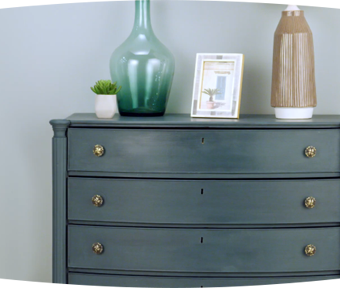 Dark teal dresser against a light gray wall