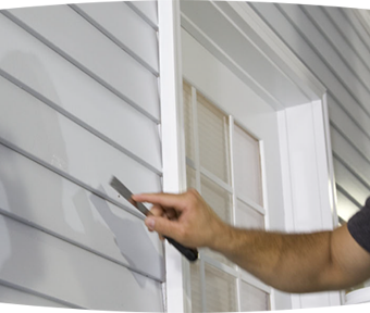 Person with a joint knife repairing siding of a house