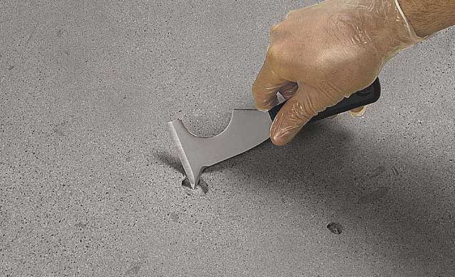 Image of a hole in concrete with a tool showing how to fix it.
