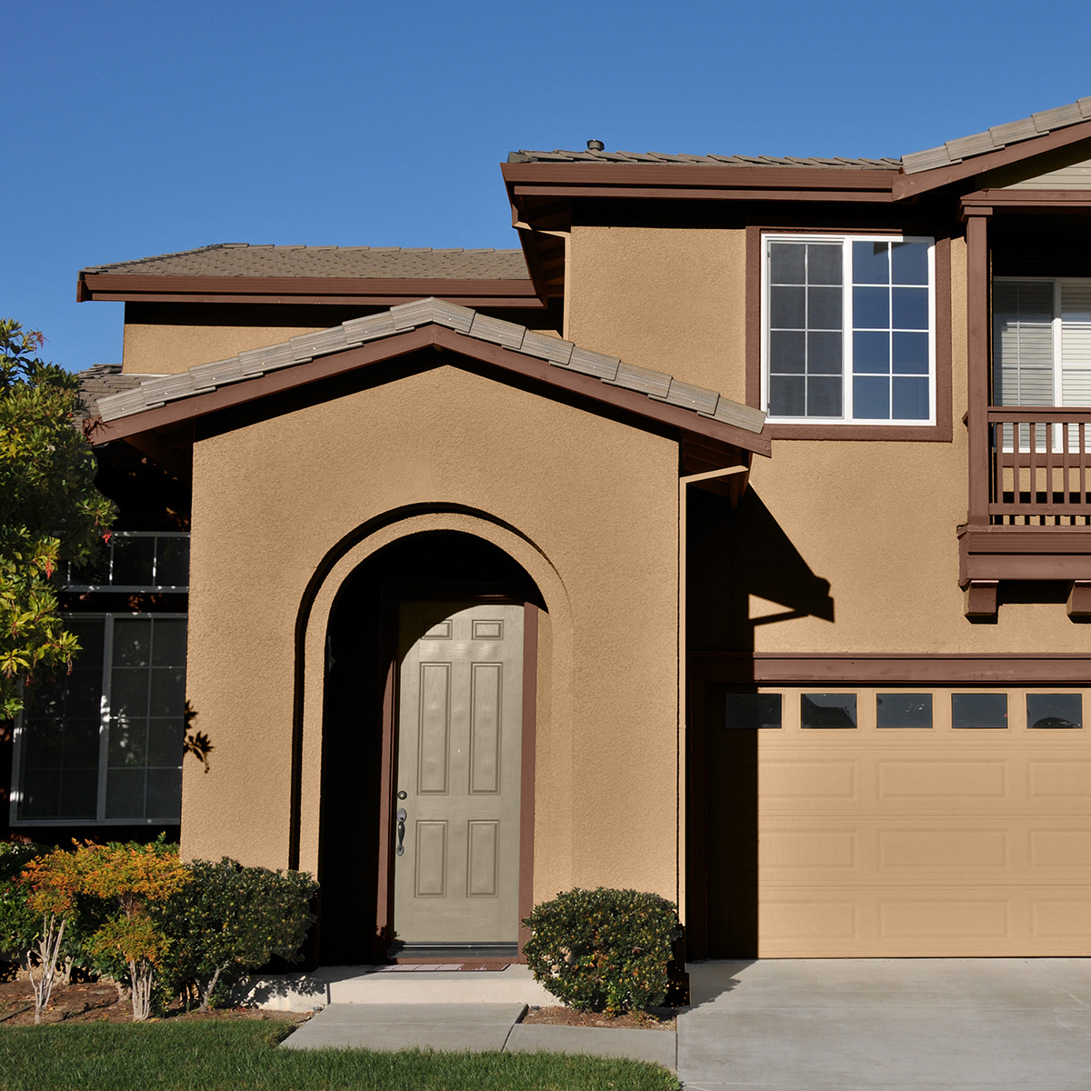 A tan house exterior painted with Behr Dynasty Exterior paint