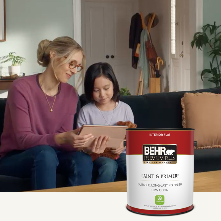 Mobile version of a family sitting in a painted living room with a Behr Premium Plus Interior Flat Paint