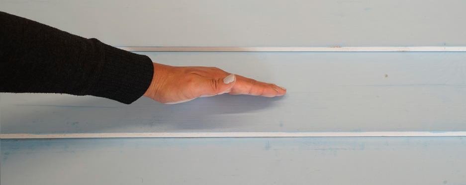 Hand checking chalkiness of painted wall, pass 6