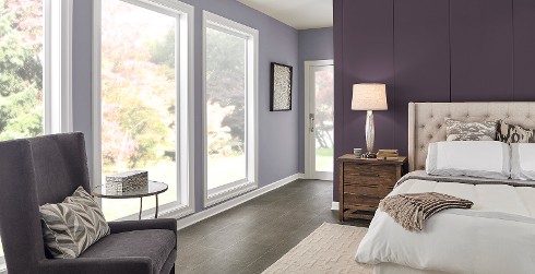 Formal styled bedroom with light purple on main walls, dark purple on accent wall, white on trim and ceiling, and tufted headboard