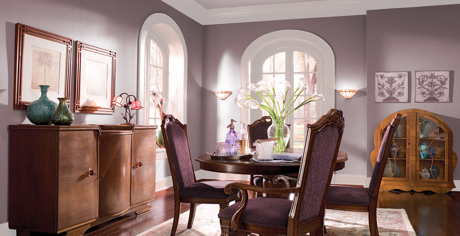 Dining room in the Art Nouveau style with mauve paint on walls, white paint on trim and pale gray on arched window trim.