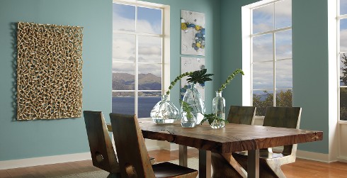 Casual dining room with Opal Silk green paint on walls, white paint on trim, wood-grained trestle dining table.