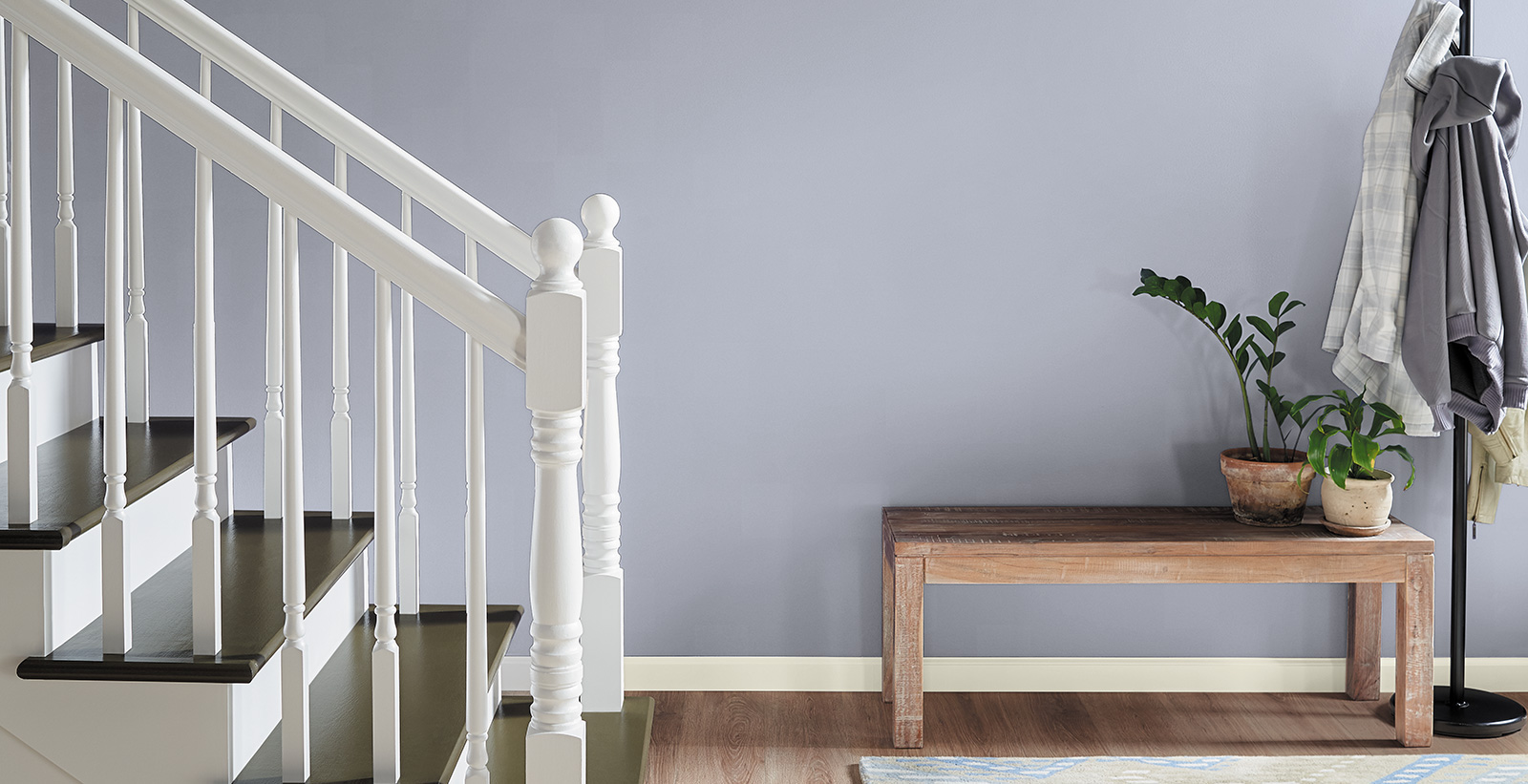 Hallway with stairs, light purple wall, and white trim, relaxed calming style.