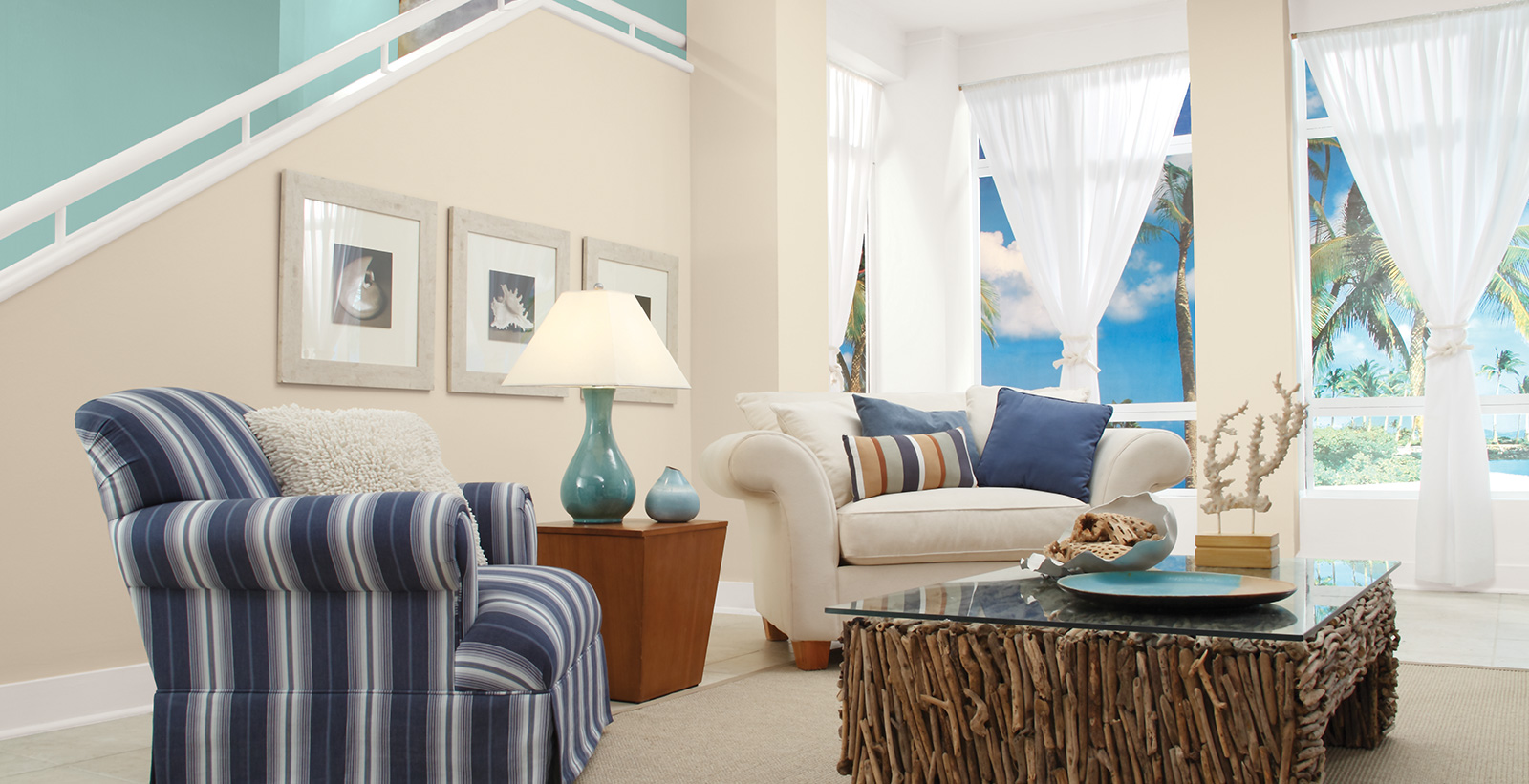 Coastal styled living room with off white on walls, white on trim, and light blue accent wall along staircase