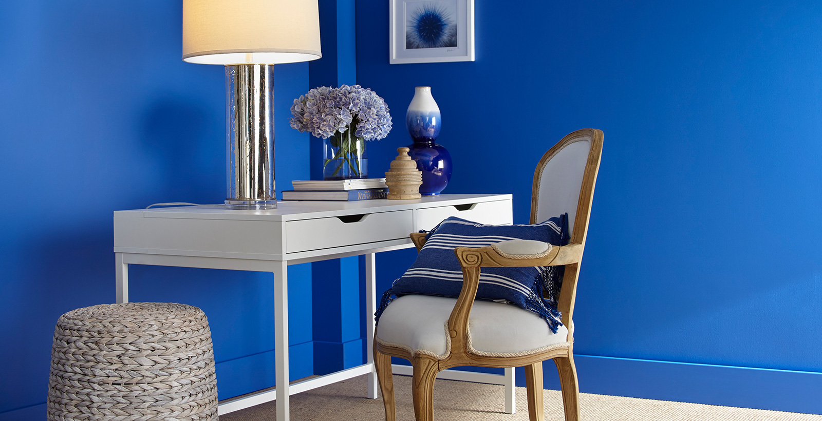 Office workspace with blue walls, and white trim, white desk, bold style.