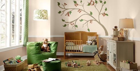 Relaxed and calming styled youth nursery room with light brown walls, white on the trim, wooden toddler bed, and painted tree.
