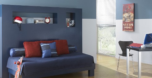 Relaxing styled youth room with light gray and blue walls, dark blue accent, and modern themed decoration.