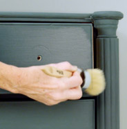 Person applying BEHR Wax Decorative Finish onto a piece of painted furniture