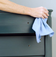 Person buffing furniture with a cloth rag