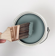Person dipping a paint brush into paint