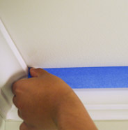 Person using painter's tape on a ceiling