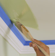Person painting a ceiling with a paint brush