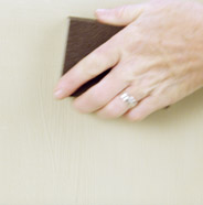 Person sanding a dresser drawer with a sanding block