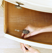 Person removing hardware and drawers from a dresser