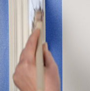 Person painting trim with a paint brush
