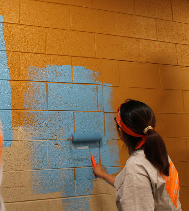 Mobile-version of Behr employee rolling paint on a wall.