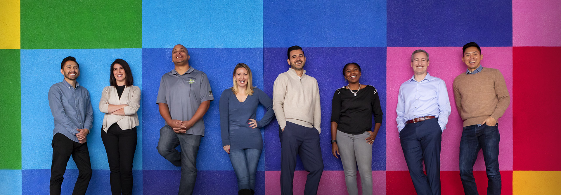 People in front of a colorfully painted wall