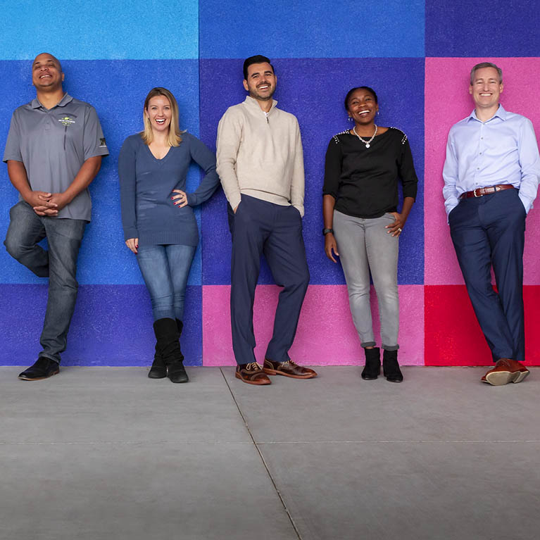Mobile image of Behr team members standing in front of colorful wall.