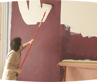A person painting a wall with extension roller
