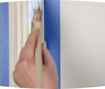 Person using a paint brush to paint trim