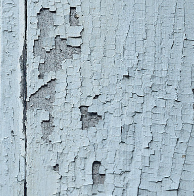 Close up image of a surface that has some cracking and flaking paint.