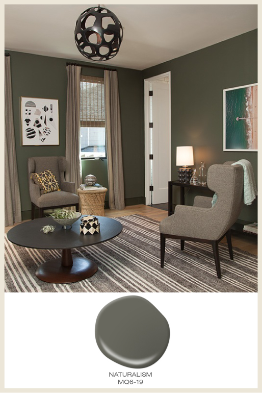 A cozy sitting area with walls painted in a dark olive green color called Naturalism.