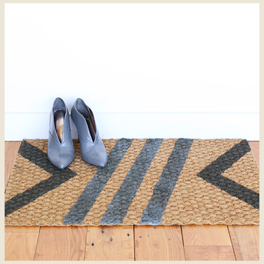 A personalized jute doormat with painted stripes and woman's shoes.