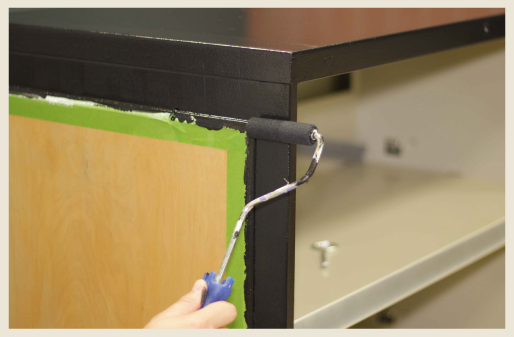 A cabinets receiving a second coat of black paint.